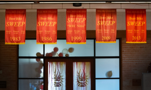 The Will Rice College Beer Bike sweep banner from Pretta's 1983 race still hangs in the residential college